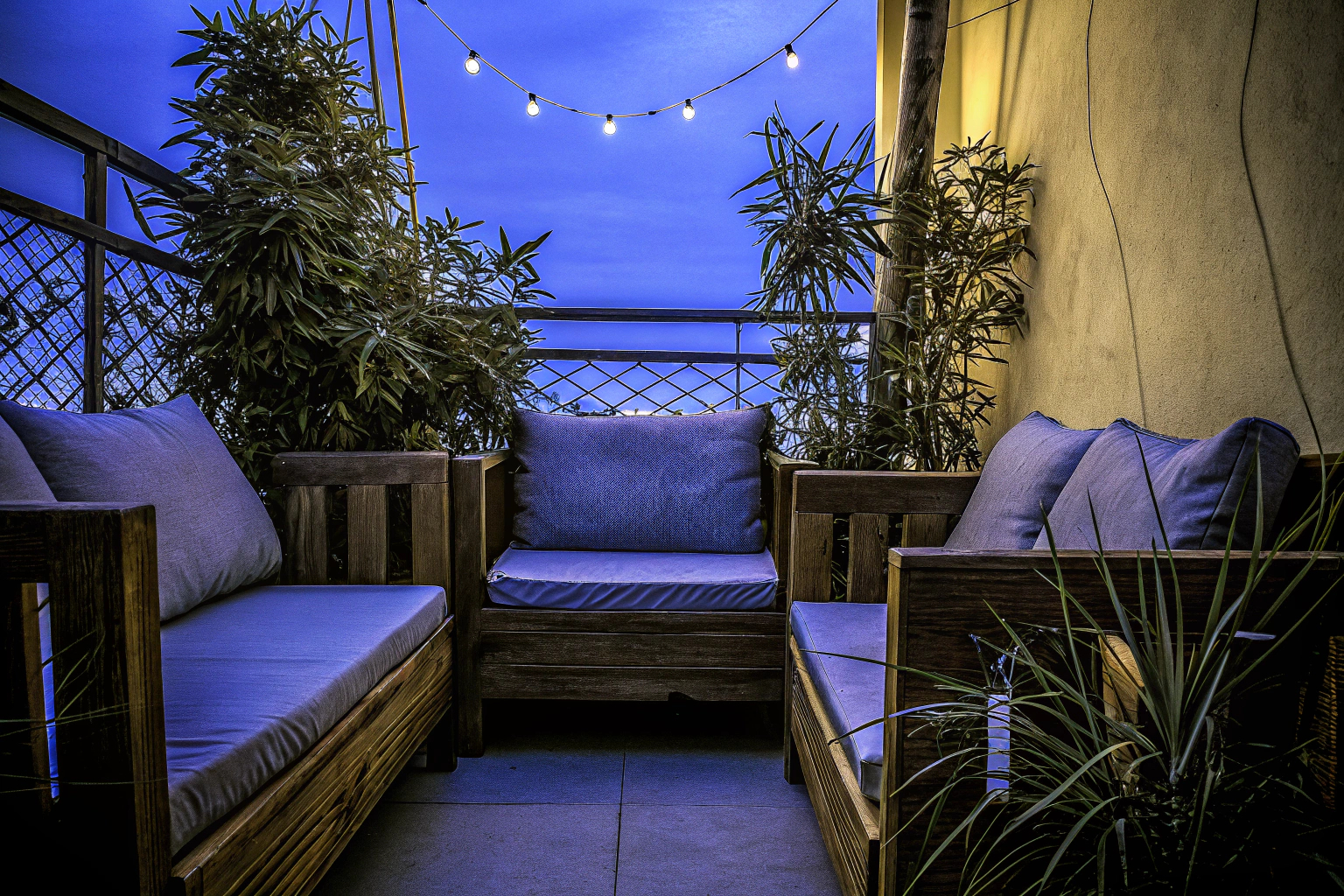 Stilvoller Balkon mit Holz- und Rattanmöbeln