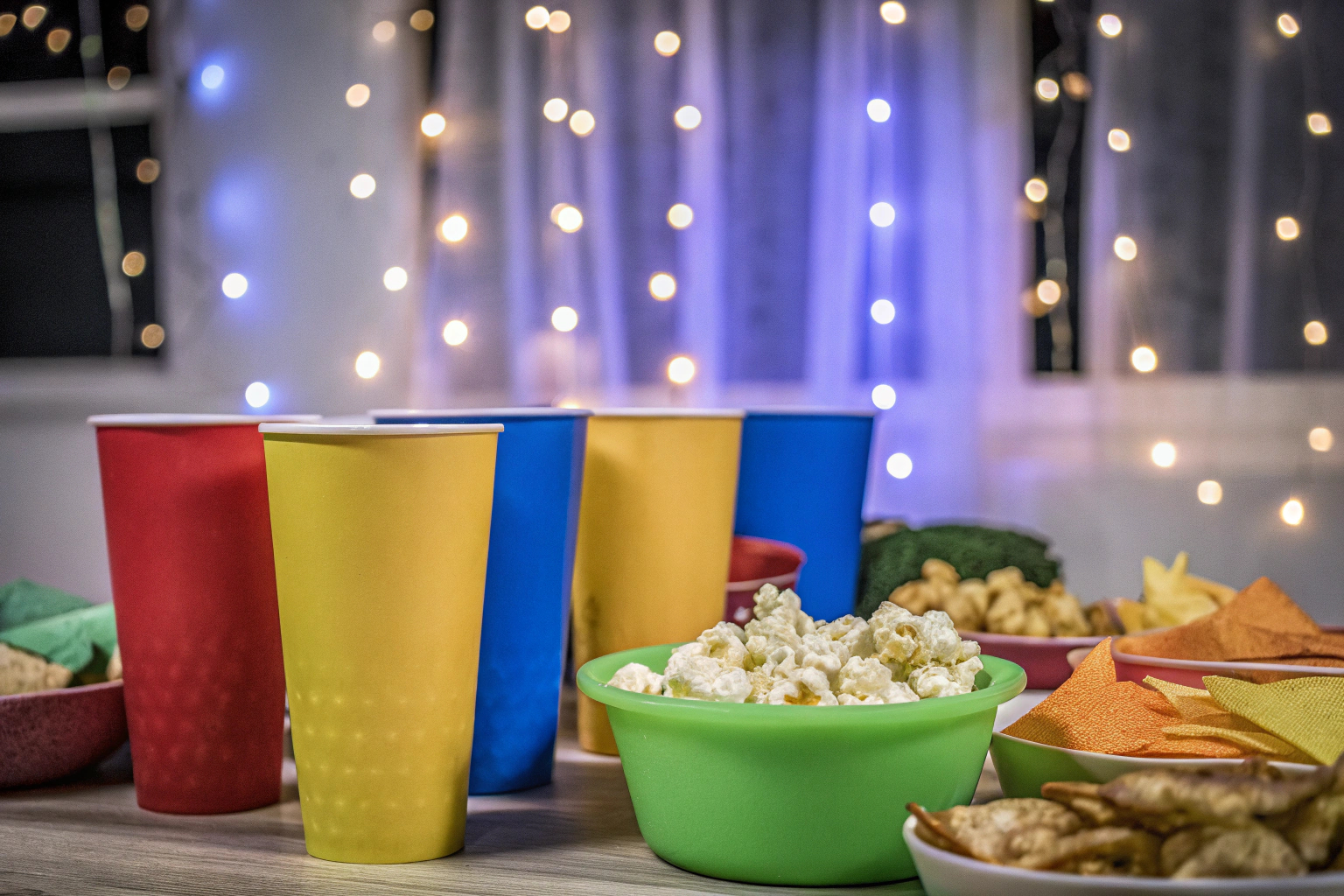 Bunte Pappbecher und Snacks auf einem Tisch